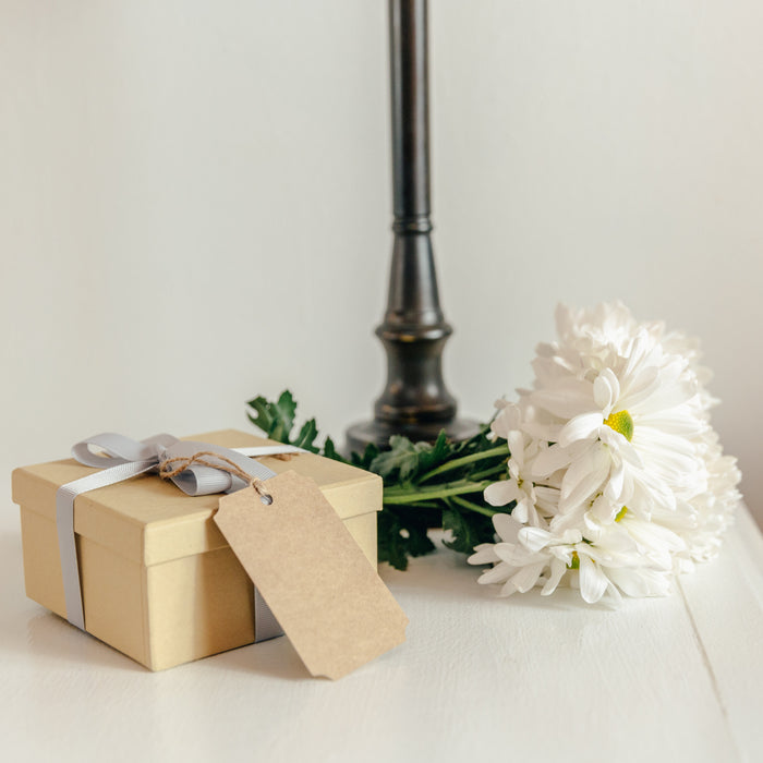 Gift With Flowers On Bedside Table