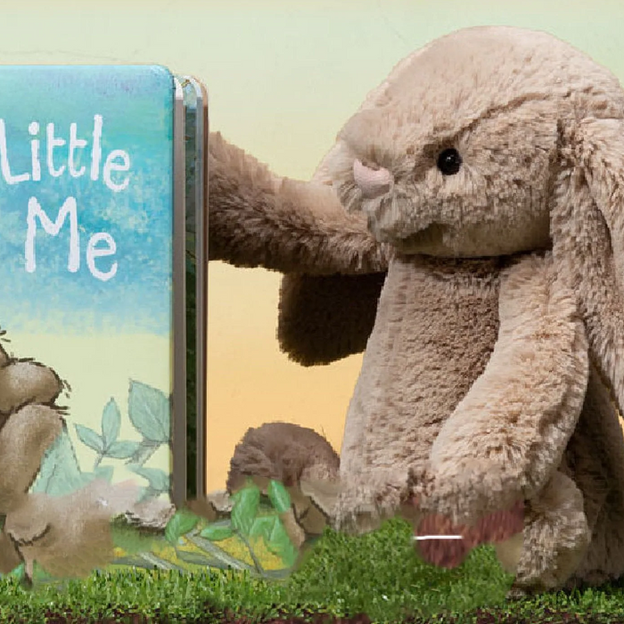 Image of Jellycat Bunny with a Jellycat Bunny Book sitting on grass.