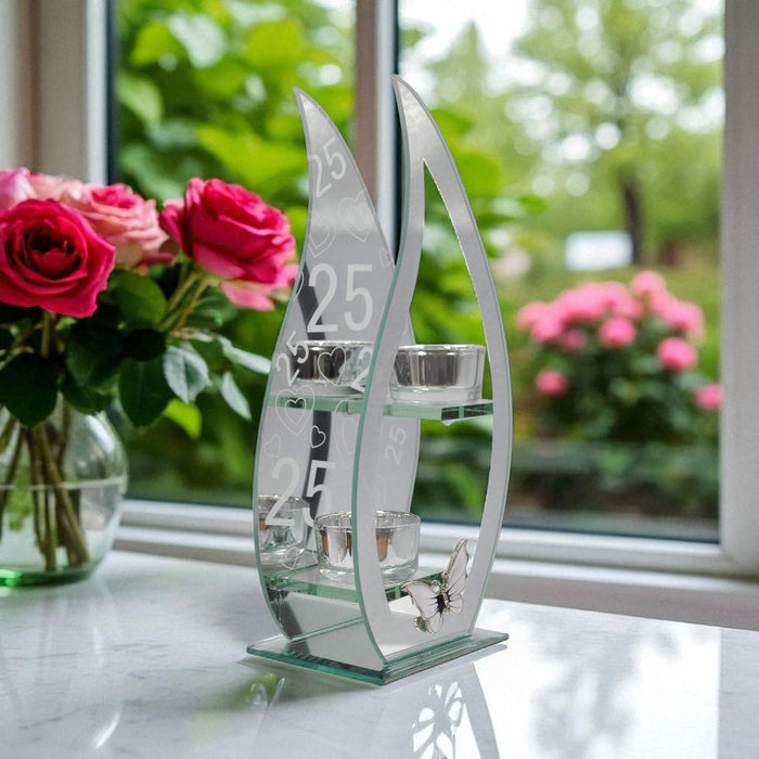 Decorative glass tealight holder with curved teardrop design and the numbers '25' on a mirrored background