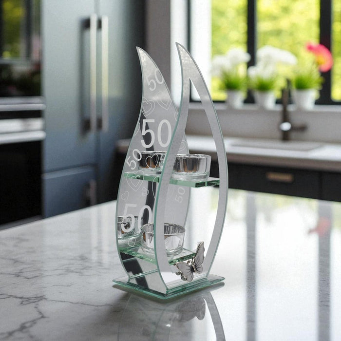 Decorative glass tealight holder with curved teardrop design and the numbers '50' on a mirrored background